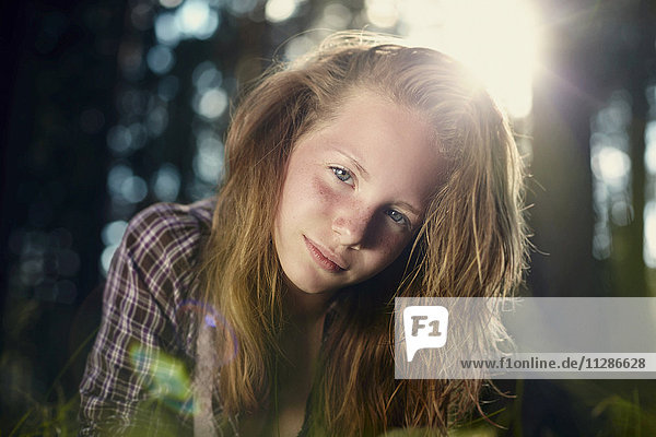 Serious Caucasian girl in sunny forest
