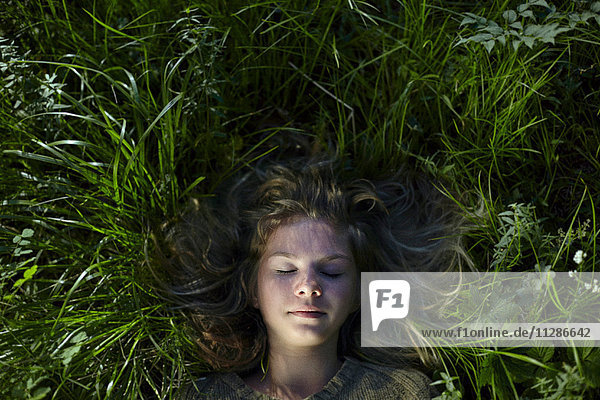 Kaukasisches Mädchen liegt im Gras