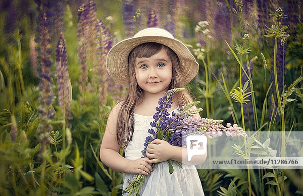 Caucasian girl holding bouquet of wildflowers