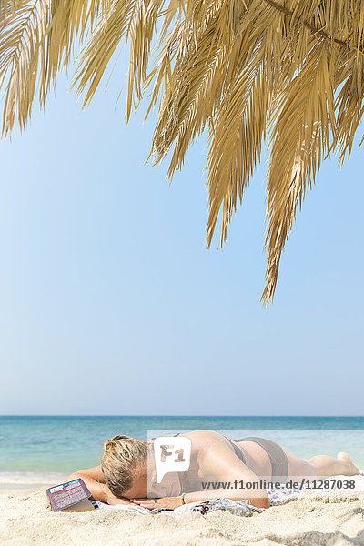 Frau beim Sonnenbaden am Strand