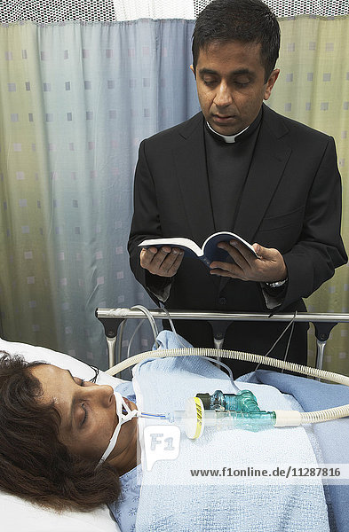 Priester erteilt Krankenhauspatienten die letzte Ölung
