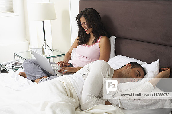 Ehepaar im Bett  Frau mit Laptop