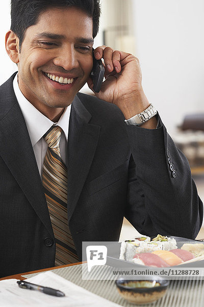 Man Using Cellular Phone at Dinner Table