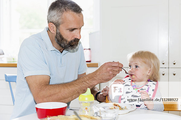 Father feeding girl