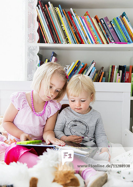 Schwestern lesen gemeinsam ein Buch