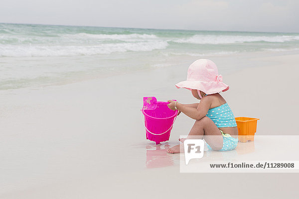 Toddler Girl Playing with Shovel and Bucket in Sand on Beach  Destin  Florida  USA