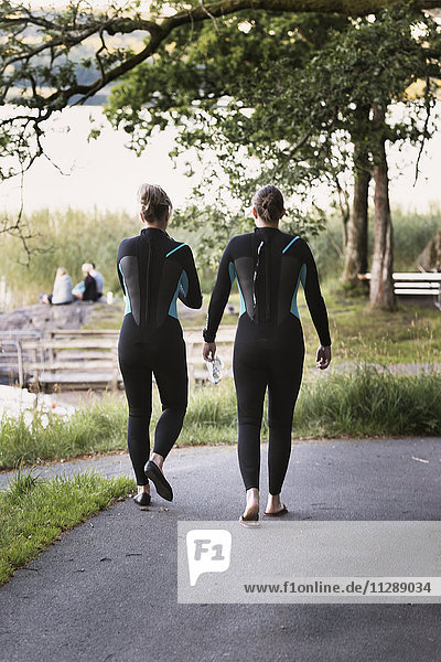 Women in wetsuits walking
