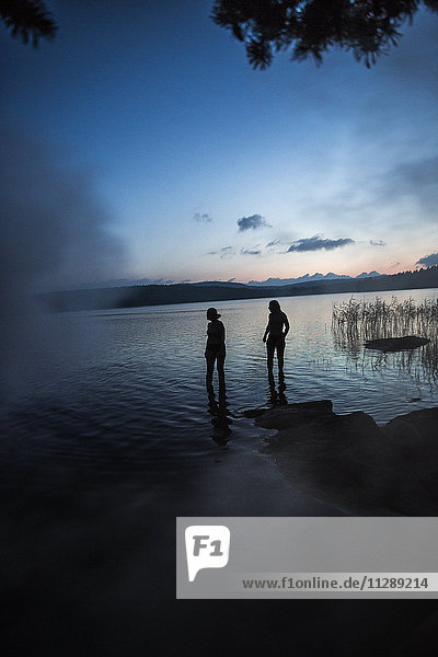 Silhouette of women at lake