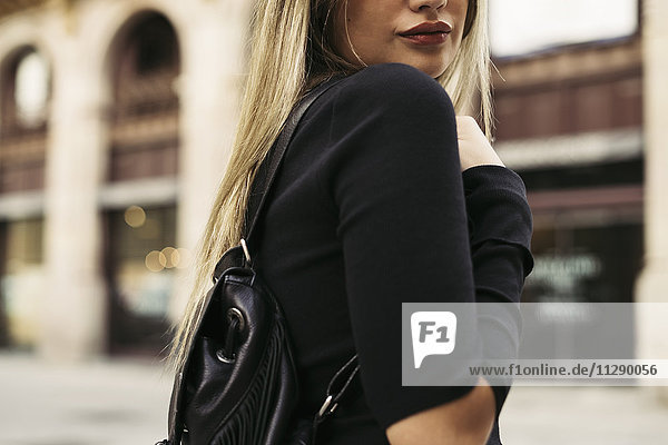 Young woman carrying shoulder bag in the city