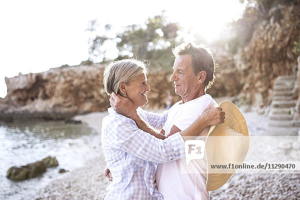 Fröhliches Seniorenpaar von Angesicht zu Angesicht am Strand
