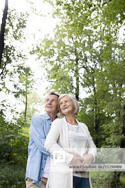 Fröhliches Seniorenpaar beim gemeinsamen Entspannen im Wald