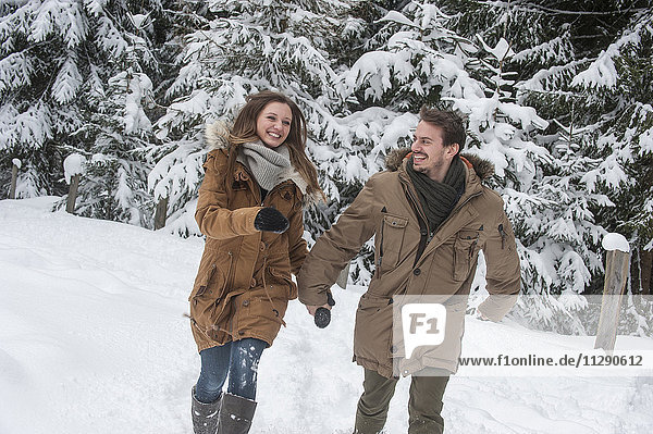 Happy couple walking in winter forest