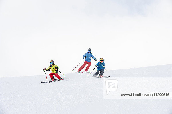 Vater und zwei Söhne beim gemeinsamen Skifahren