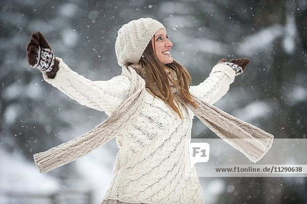 Glückliche blonde Frau in Strickwaren im Winter