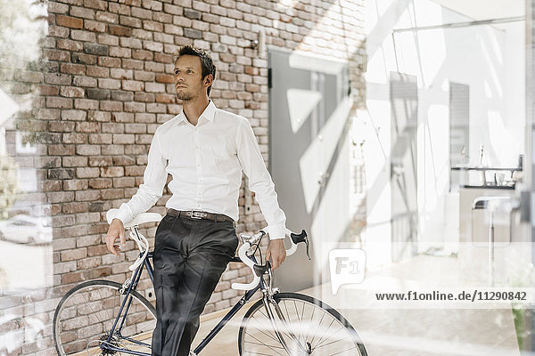 Geschäftsmann mit Fahrrad im Büro