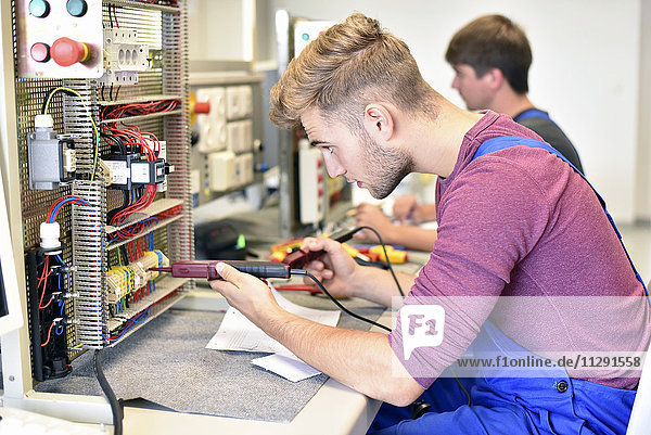 Zwei Elektriker-Schüler  die am Schaltschrank arbeiten