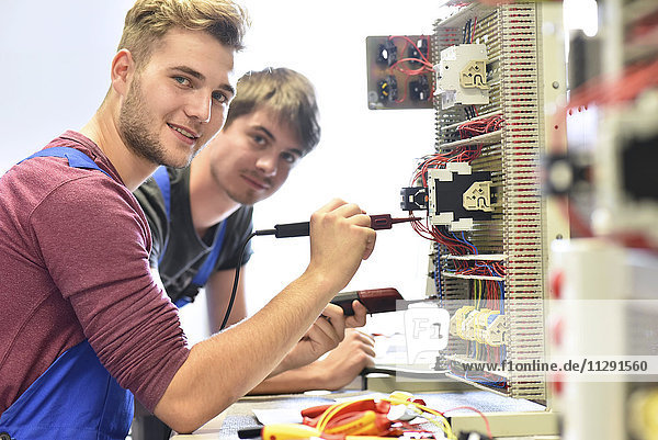 Zwei Elektriker-Schüler  die am Schaltschrank arbeiten