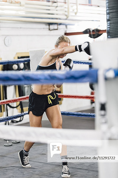 Female boxer punching in boxing ring