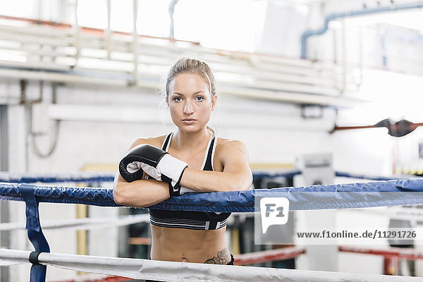 Portrait of confident female boxer in boxing ring