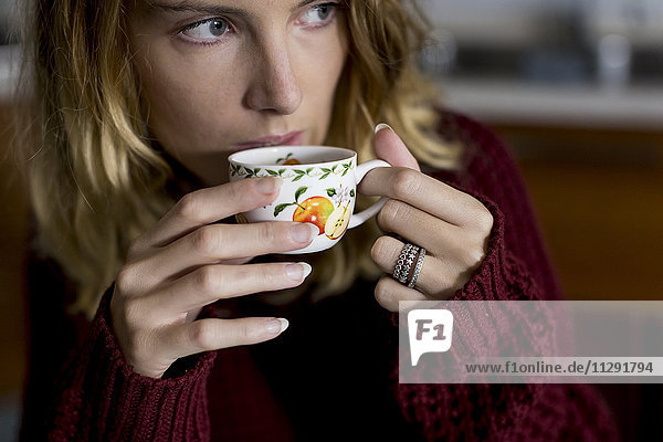 Woman drinking a cup of coffee at home