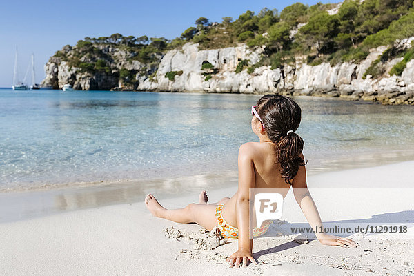 Kleines Mädchen beim Sonnenbaden am Strand