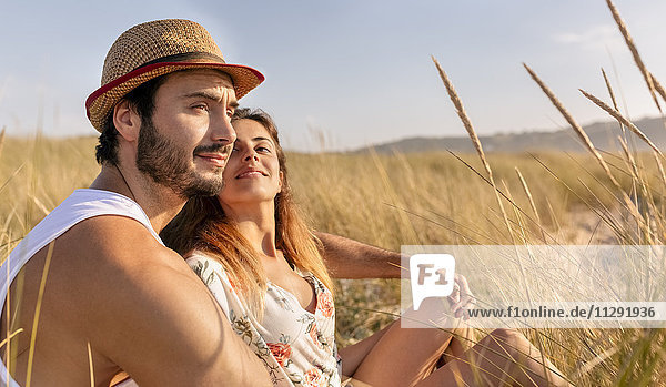 Couple in love sitting on a meadow