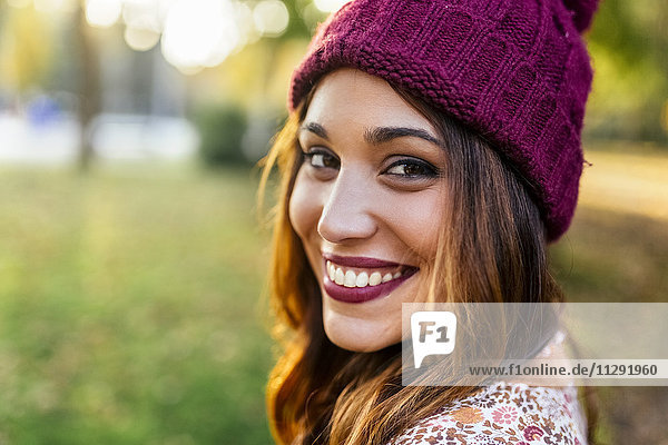 Porträt einer lächelnden jungen Frau mit Wollmütze
