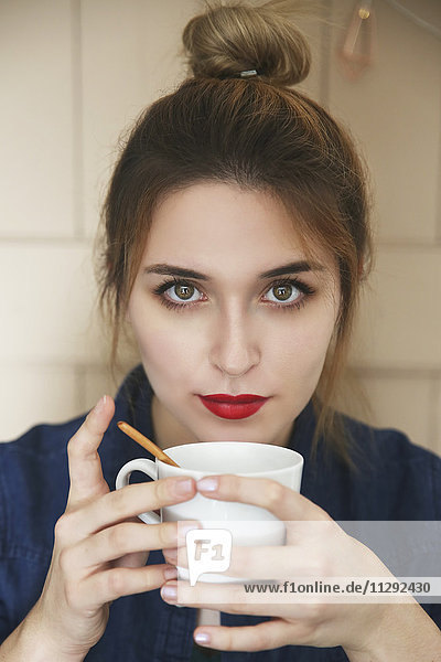 Porträt einer jungen Frau mit einer Tasse Kaffee