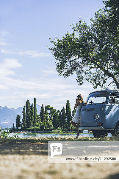 Italien  Gardasee  junge Frau beim Kaffeetrinken im Campingbus