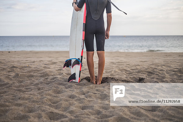 Spanien  Teneriffa  Junge mit Surfbrett am Strand