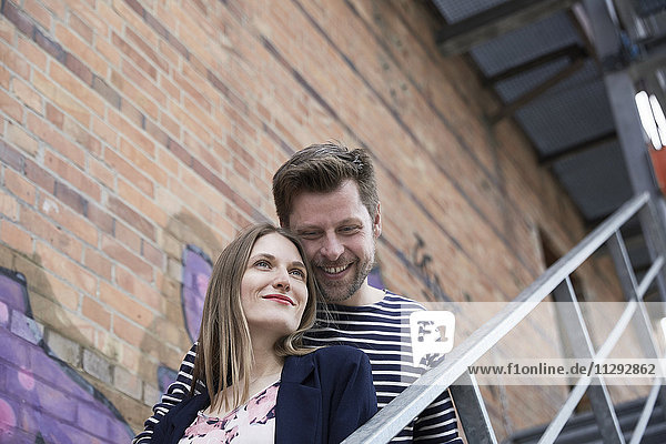 Lächelndes Paar auf der Treppe im Freien