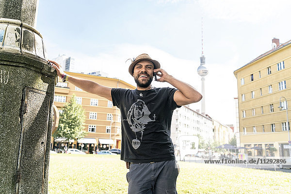 Deutschland  Berlin  lächelnder Mann am Telefon mit Fernsehturm im Hintergrund