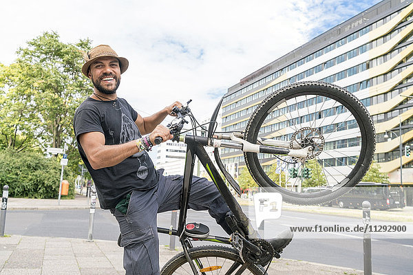 Porträt eines lächelnden Mannes mit Fahrrad