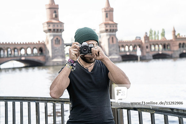 Deutschland  Berlin  Mann vor Oberbaum beim Fotografieren vom Zuschauer