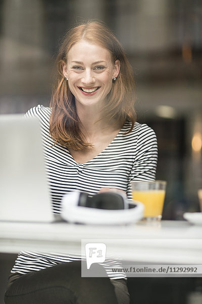 Porträt einer glücklichen Frau  die in einem Café sitzt.