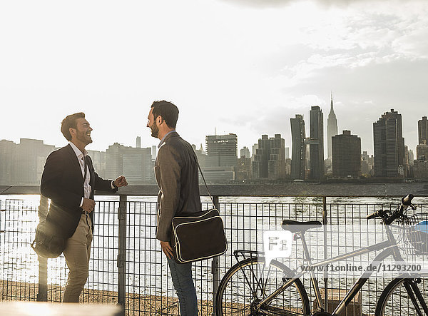 USA  New York City  zwei Geschäftsleute mit Fahrrad am East River