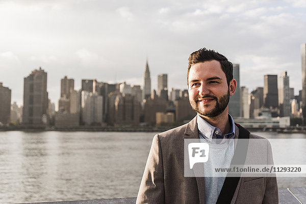 USA  New York City  Porträt eines selbstbewussten Geschäftsmannes am East River