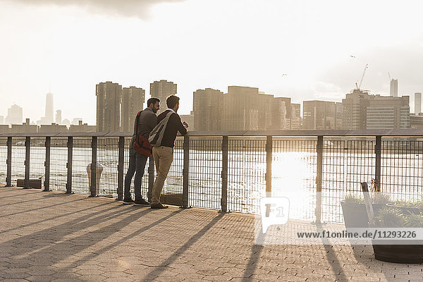 USA  New York City  zwei junge Männer im Gespräch am East River