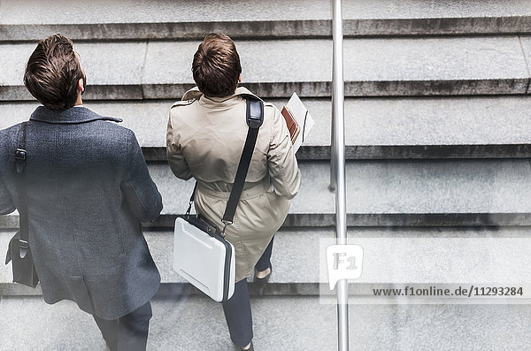 Businessman and woman walking on stairs