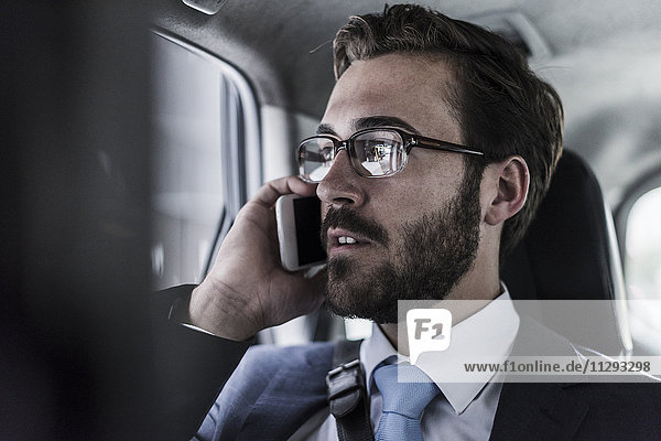 Businessman on cell phone in a car