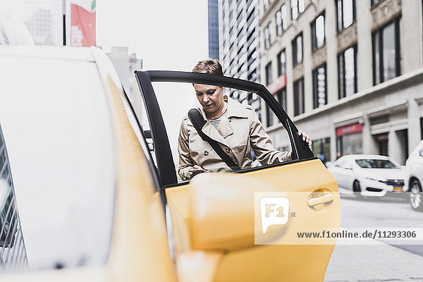 USA  New York City  Frau in Manhattan beim Einsteigen in ein Taxi