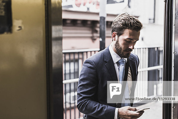 Junge Geschäftsleute mit der U-Bahn  mit dem Smartphone