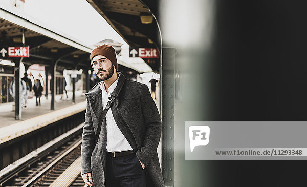 Young man waiting at metro station platform