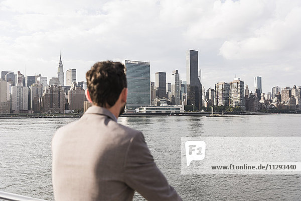 USA  New York City  Rückansicht des Mannes am East River mit Blick auf Manhattan