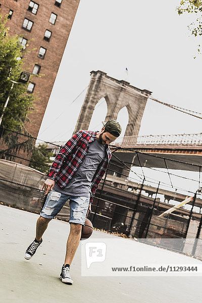 USA  New York  junger Mann beim Basketball auf einem Außenplatz