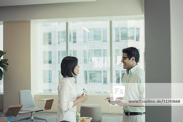 Businessman and woman talking in office