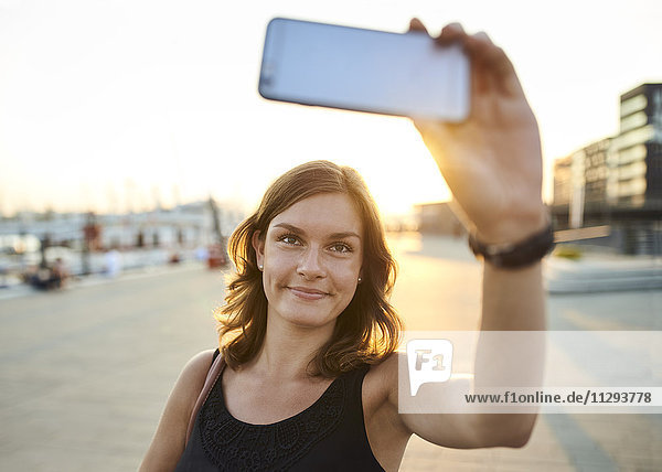 Deutschland  Junge Frau in Hamburg nimmt Selfie mit ihrem Smartphone