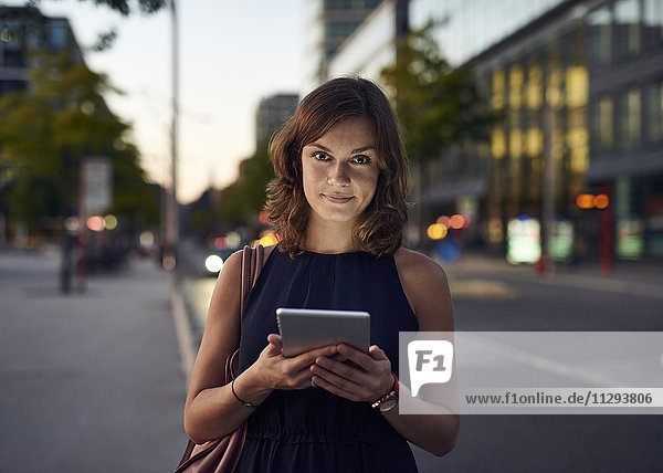 Deutschland  Hamburg  Junge Frau auf der Straße mit digitalem Tablett
