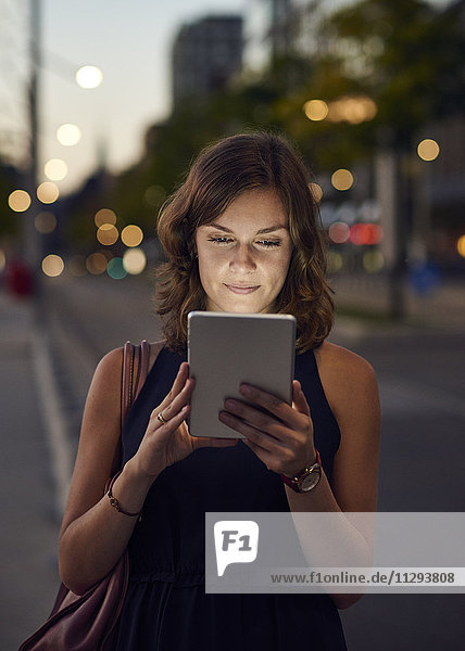 Deutschland  Hamburg  Junge Frau auf der Straße mit digitalem Tablett