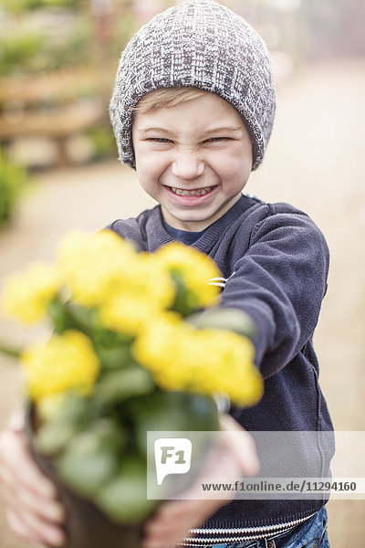 Junge mit gelbem Blumentopf